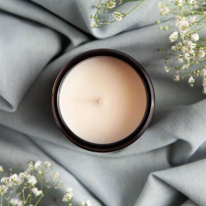 Love Spell soy candle in 9oz amber glass jar with gold lid, tangy cranberry, spices, and vanilla scent, vegan and non-toxic with 70+ hour burn time
